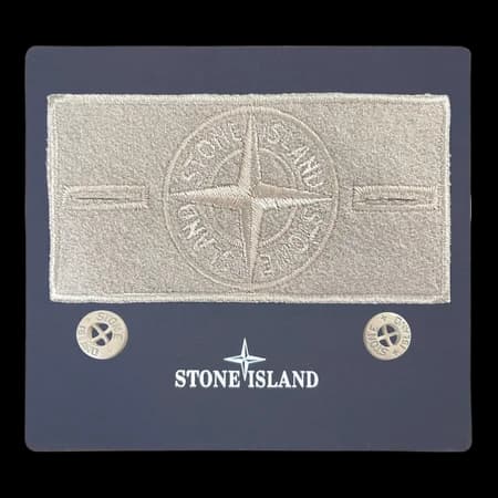 Front view of monochromatic beige compass badge