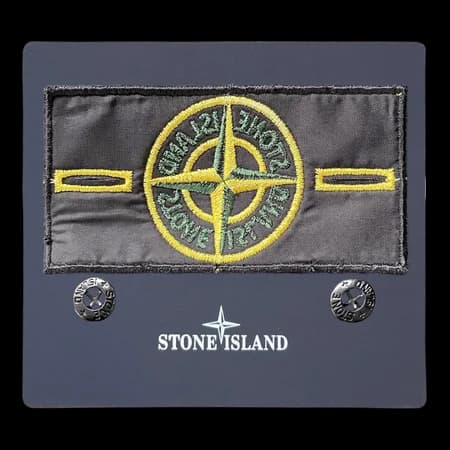Close-up of a Stone Island badge showing button attachment points